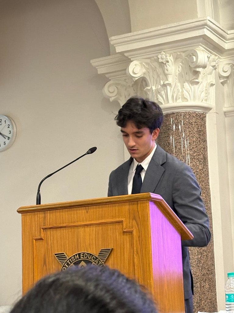 Rayhan speaking at a podium